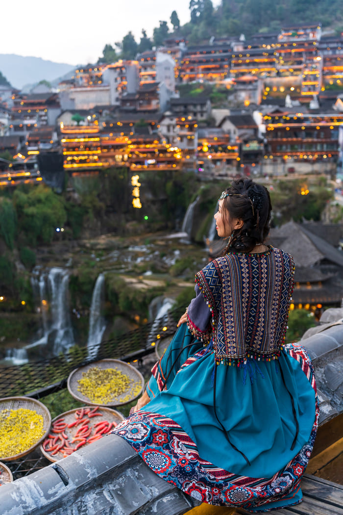 mujer sentada contemplando el paisaje en la ciudad de lijiang