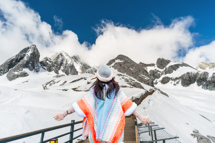 mujer posando en una montaña con nieve